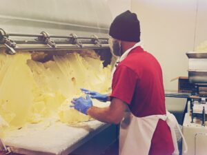 Man Stands Before a Machine Making Butter